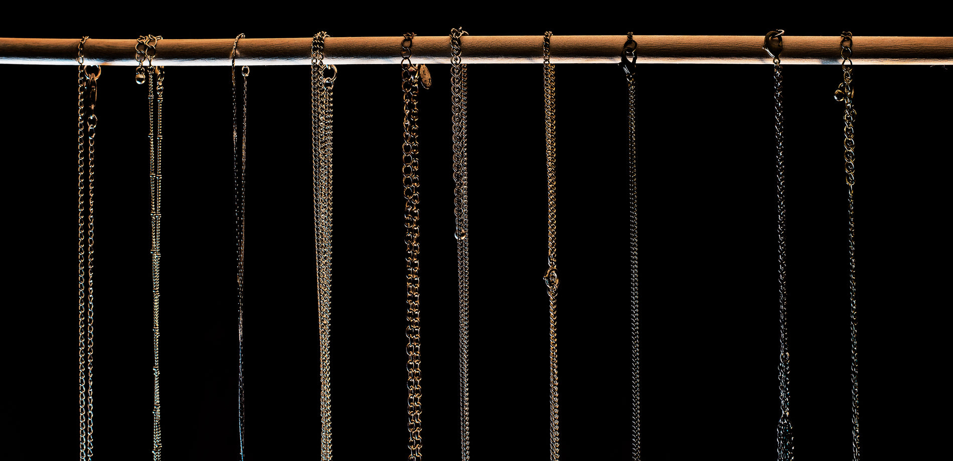 Fine chains hanging in rows against a dark background