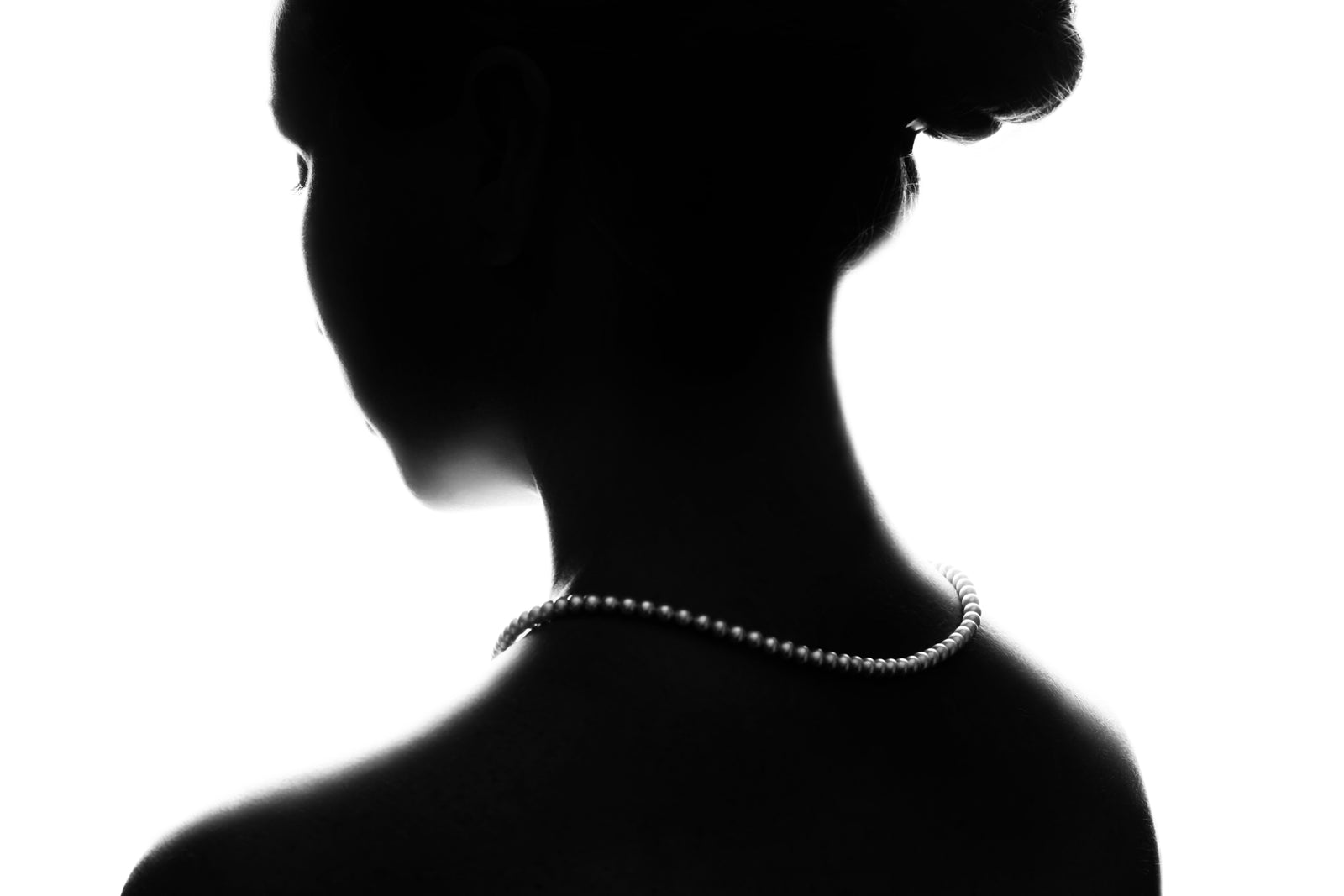 Silhouette of a woman wearing a beaded choker